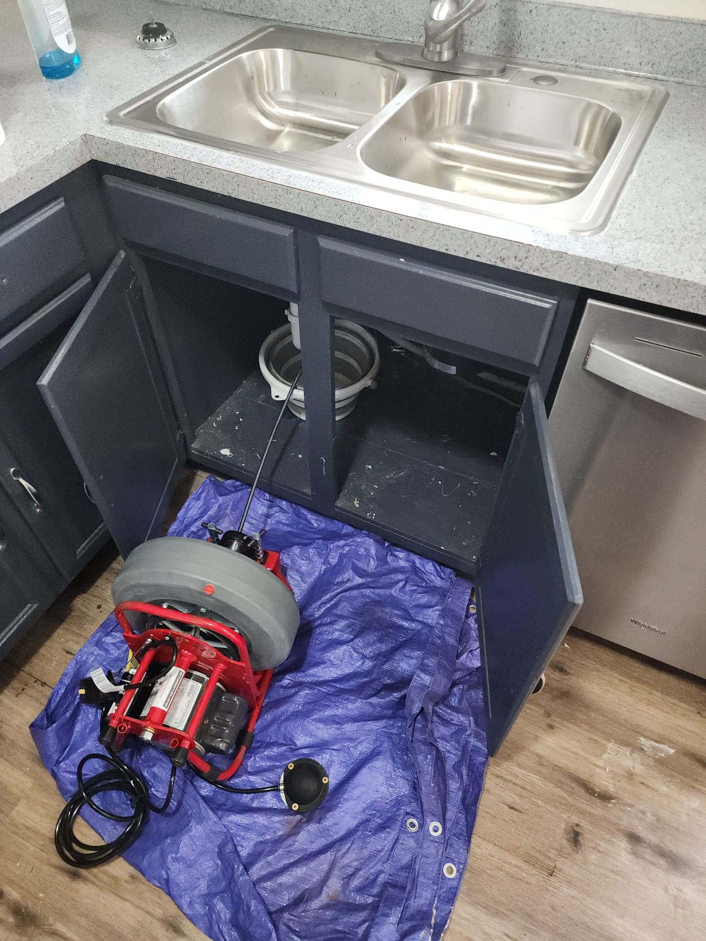 On-Call Rooter cleaning a kitchen drain under the sink in Aurora, Colorado